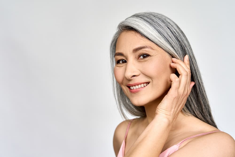 A confident woman with glowing skin and bright eyes, reflecting the smoothing and firming benefits of the Eye Lift & Contour treatment at The Zen Den.