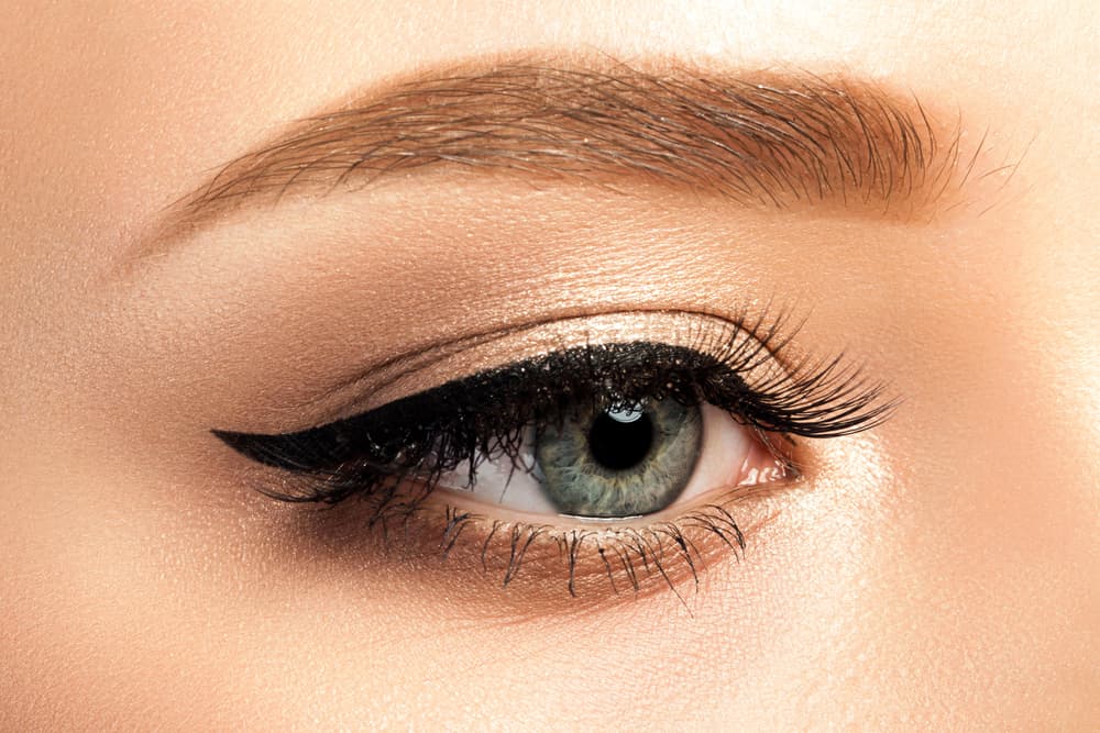 Close-up of a blue-grey eye with long, dark lashes after a professional eyelash tint at The Zen Den, enhancing the eye’s natural beauty.