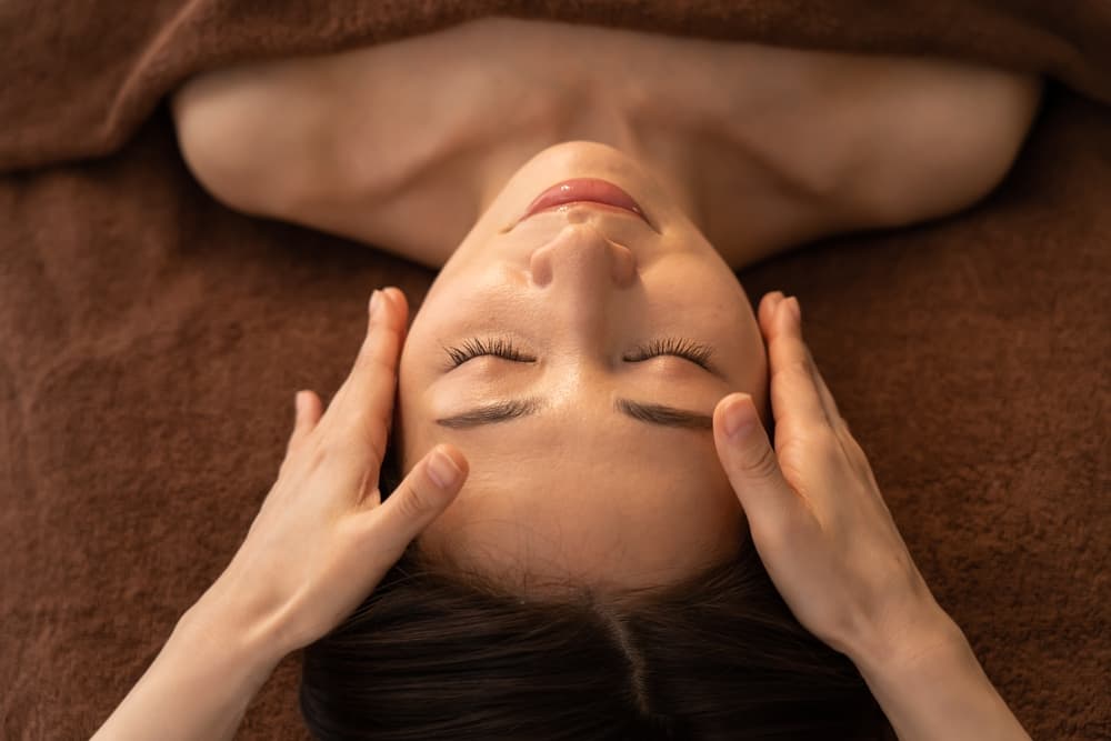 Close-up of a client receiving a soothing facial massage at The Zen Den, designed to relax facial muscles, boost circulation, and enhance skin radiance.