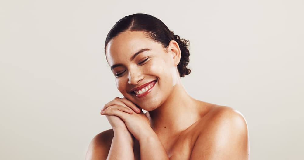 Smiling woman with glowing, radiant skin after a Glow Up Facial at The Zen Den, showing smooth, healthy, and hydrated complexion.