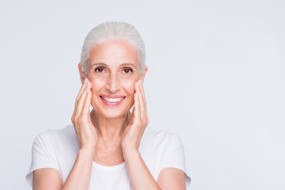 A smiling woman with lifted, radiant skin after a Hydradermie Lift Deluxe facial at The Zen Den, a premium treatment that tones and firms the face.