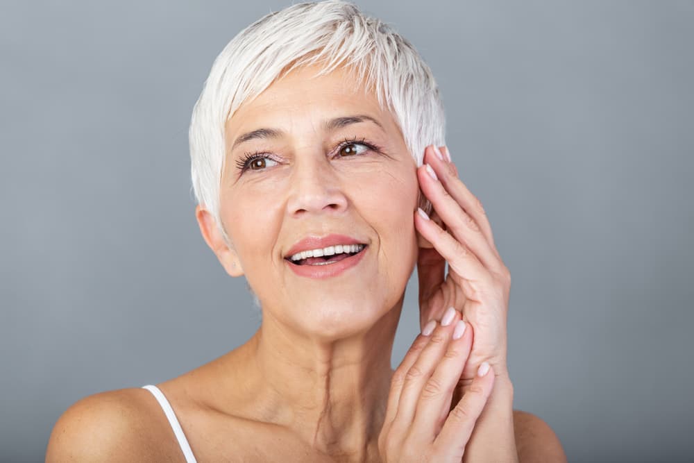 A joyful woman with firmer, brighter skin after a Hydradermie Lift Express facial at The Zen Den, a quick toning treatment for visible results.