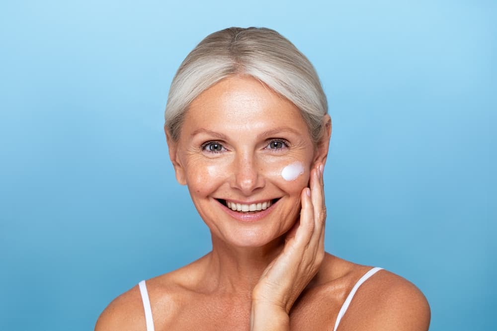A smiling woman with fresh, glowing skin after the Hydradermie Youth facial at The Zen Den, designed to smooth lines and boost radiance.
