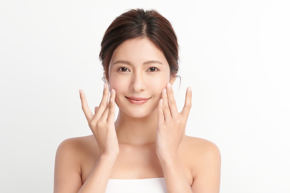 A woman with radiant, healthy skin after a HydrO2 Deep Vibrational Facial at The Zen Den, designed to stimulate circulation and promote glow.