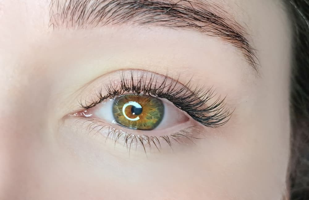 Close-up of a beautifully lifted and curled natural lash after a lash lift treatment at The Zen Den, highlighting the eye’s green and amber tones.