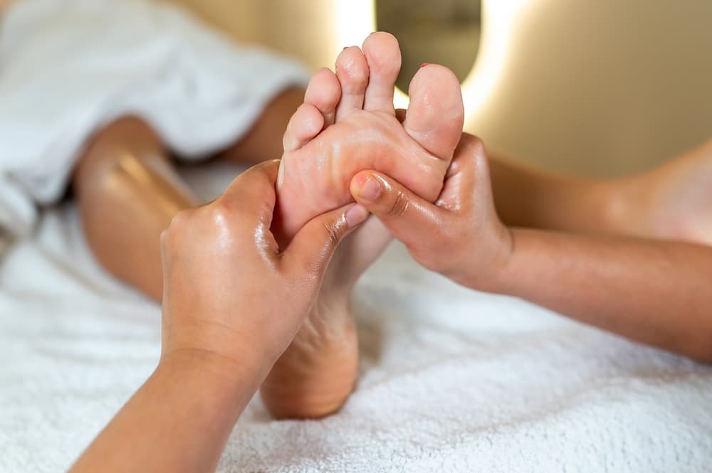 Close-up of a relaxing mini foot massage at The Zen Den, with hands gently applying pressure to soothe and refresh tired feet.