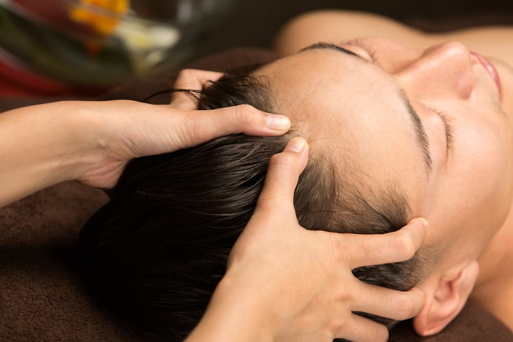 Close-up of a relaxing mini head massage at The Zen Den, with gentle fingertip pressure to ease tension and promote calm.
