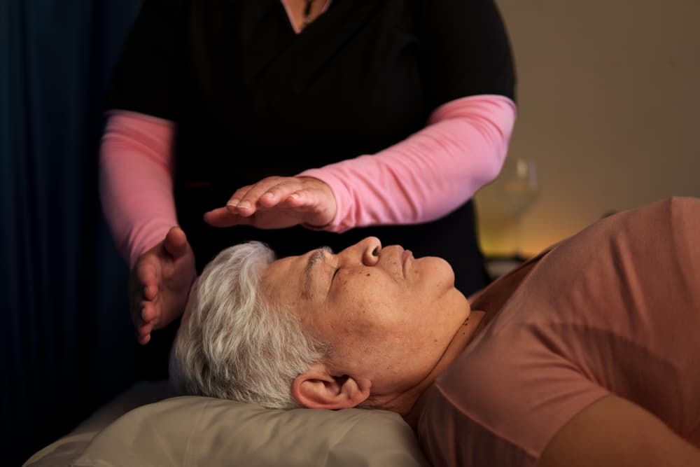 Mini reiki session at The Zen Den, with a practitioner using gentle hand positions to channel calming energy and promote relaxation.