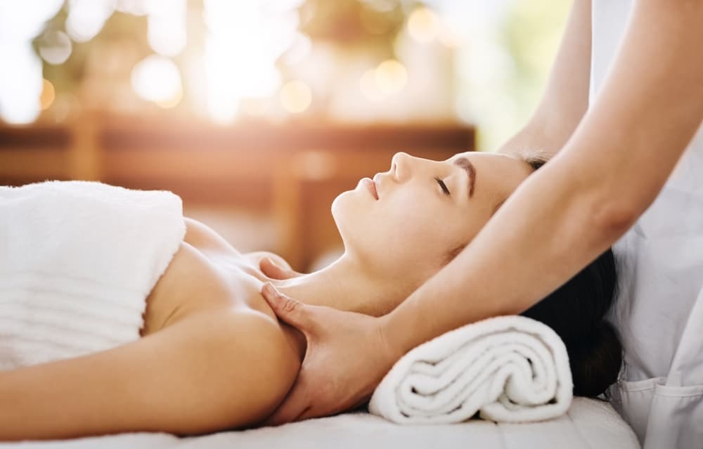 Mini shoulder massage at The Zen Den, with a client relaxing on a massage bed while the therapist eases tension in the neck and shoulder area.