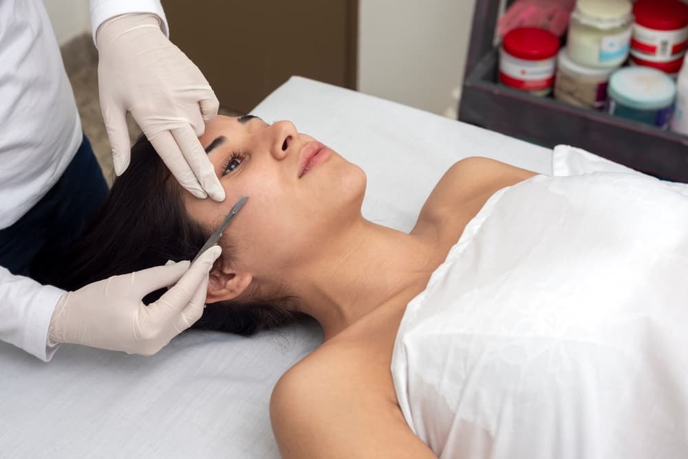 A client receiving the Oilaplane facial at The Zen Den, a gentle exfoliating treatment using a nourishing oil and dermaplaning technique to reveal softer, brighter skin.