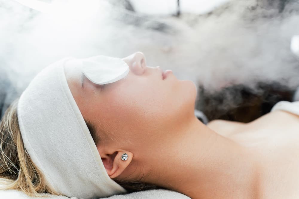 Close-up side profile of a woman receiving an ozone steam add-on treatment at The Zen Den, with a gentle flow of steam directed at her face for deep cleansing and hydration.