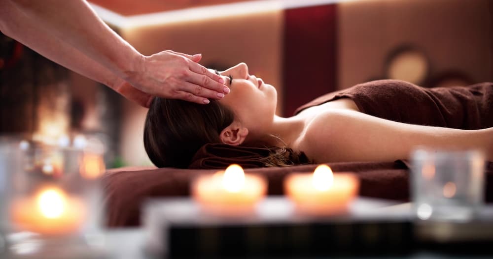 Reiki 60-minute master level session at The Zen Den, offering deep energy healing and relaxation in a tranquil candlelit setting.